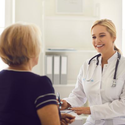  younger female doctor talking to an older female patient