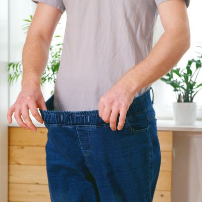 man in pants that are too large to show effects of bariatric surgery