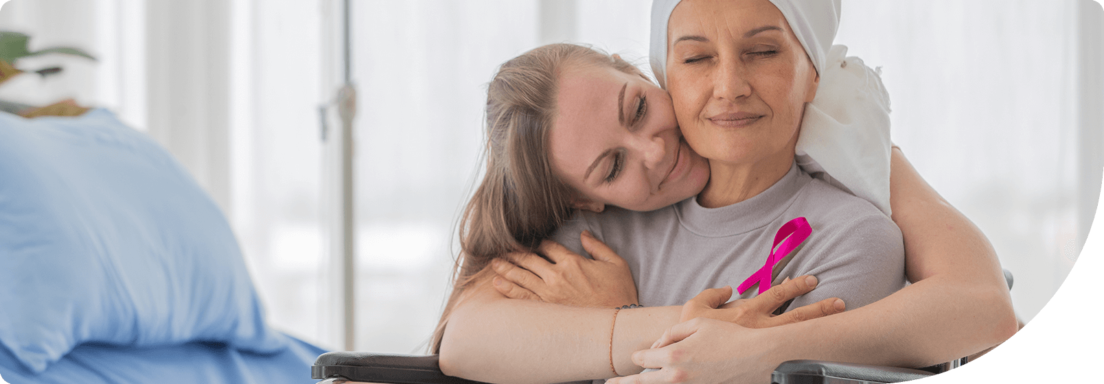 younger woman with her arms around an older woman undergoing chemotherapy for breast cancer