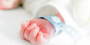 Closeup of a baby's hand with a hospital wristband