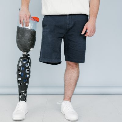 Man standing on one foot next to his prosthetic leg